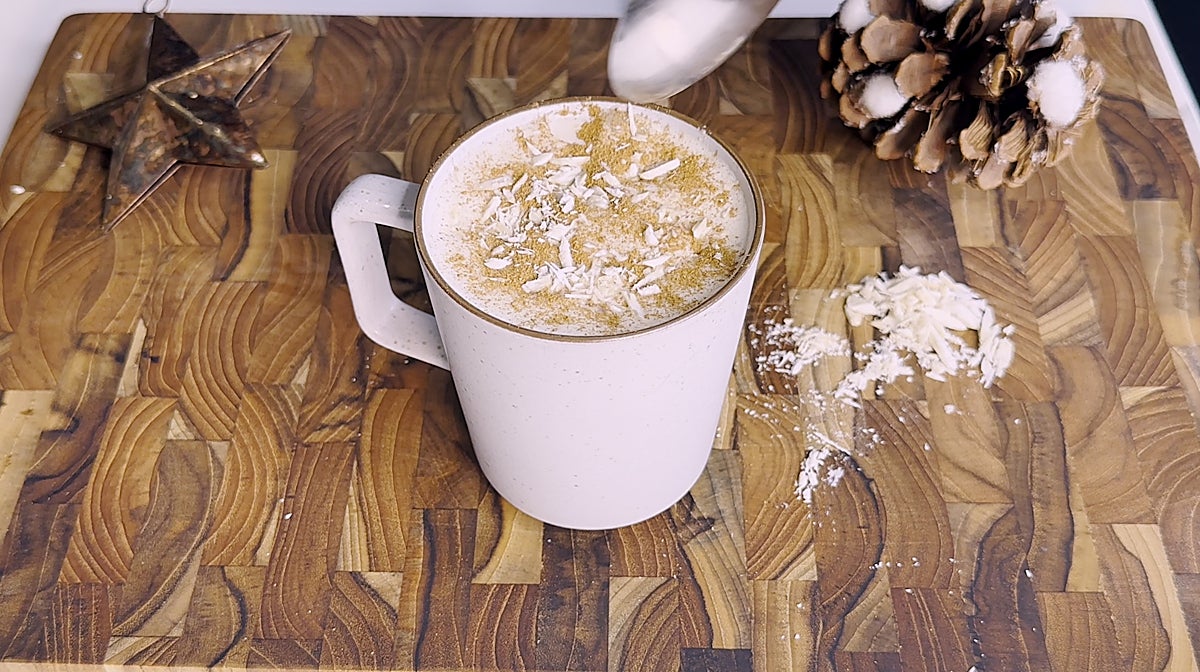 Bebida de turrón decorada con almendras y canela.