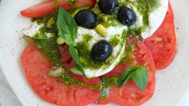 Detalle del emplatado de la ensalada de tomate rosa y pesto de pistacho.