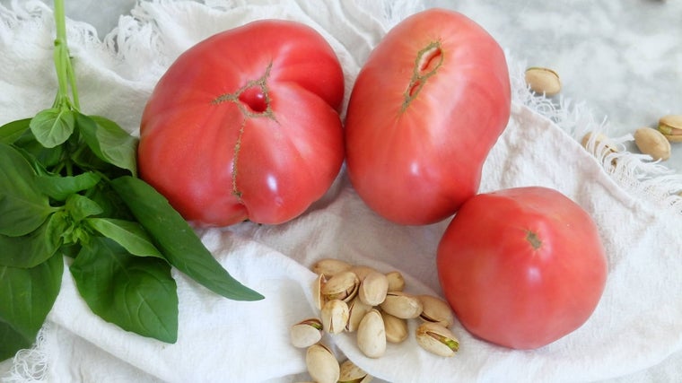 Tomate, hojas de albahaca y pistachos.