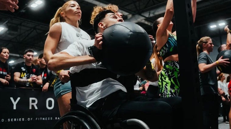 Miriam asistiendo a un atleta en silla de ruedas participando en la Hyrox de Madrid 2022
