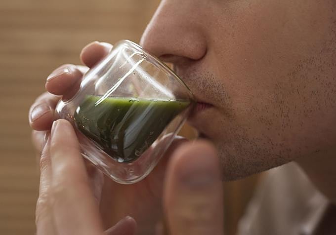 Persona bebiendo té matcha de la forma tradicional.