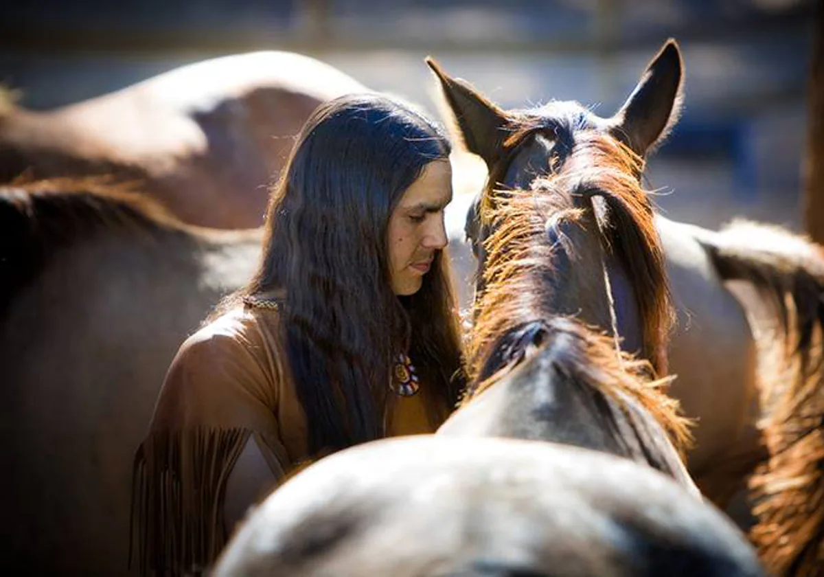 Un nativo americano cuidando una manada de caballos