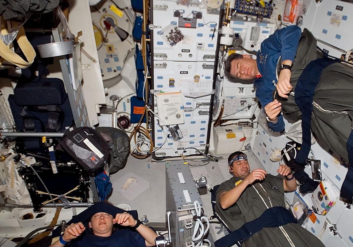 De izquierda a derecha, los astronautas de la NASA Pam Melroy, George Zamka y el de la ESA Paolo Nespoli descansan en el transbordador Discovery acoplado a la ISS en 2007