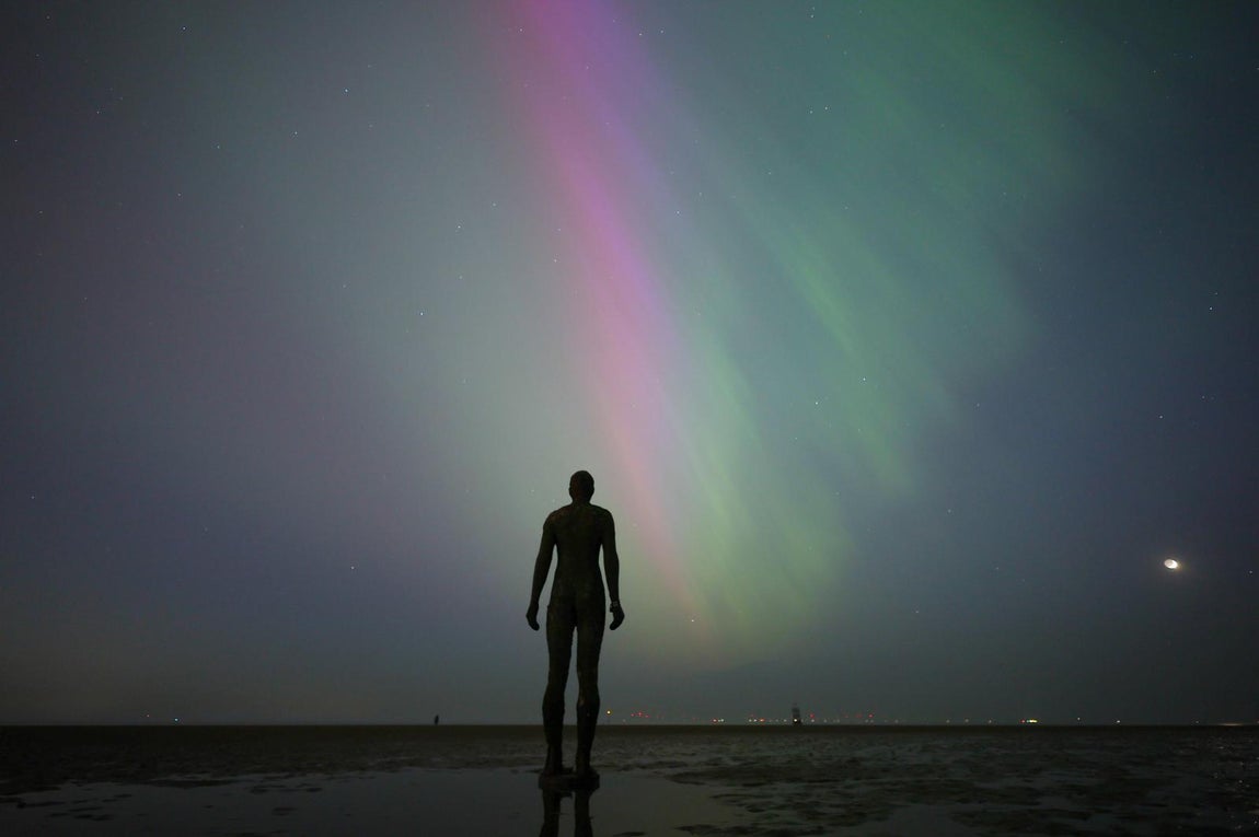 La estatua de Another Place de Antony Gormley ante la aurora boreal en Crosby (Reino Unido)
