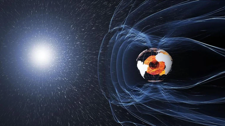 El campo magnético de la Tierra es generado por el núcleo (en naranja). Protege la atmósfera frente al viento solar y la superficie de los rayos cósmicos