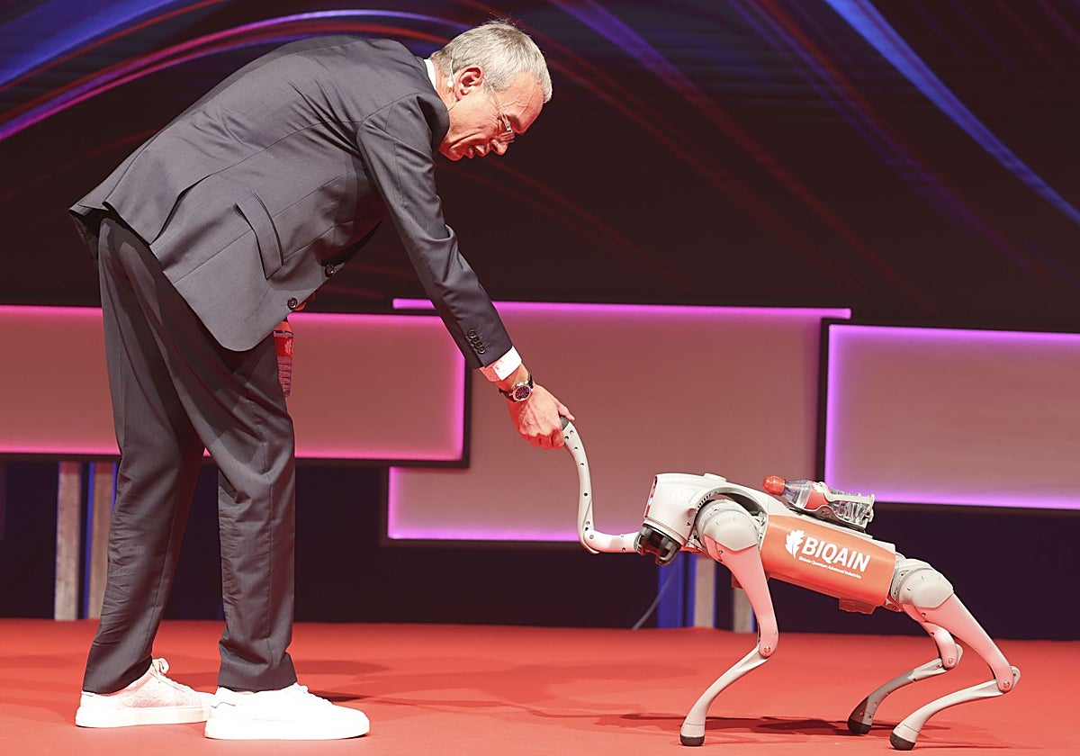 Valentín García saluda a un perro-robot que incorpora un sensor cuántico para guiarse durante la celebración de la segunda edición de QuantumNow