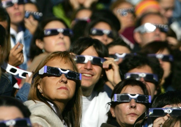 Un multitudinario grupo de personas contempla un eclipse de Sol