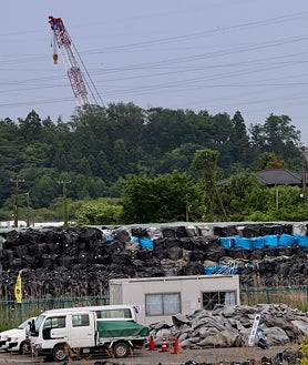 Imagen secundaria 2 - «»«Acceso cerrado por ser zona de difícil regreso en el futuro, reza la señal ante la valla que impide el paso a una cementera próxima a la central nuclear de Fukushima 1 (primera imagen superior). En el puerto de Soma, a unos veinte kilómetros de la planta atómica, los pescadores temen el daño que provocará el vertido del agua tratada tras enfriar sus reactores fundidos (arriba a la izquierda). Visibles desde la Ruta 6, que pasa junto a la central, sacas negras y azules almacenan los escombros radiactivos de su desmantelamiento (arriba a la derecha). 
