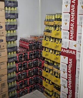 Imagen secundaria 2 - Santos Muñoz tomando nota de reservas en el bar y ante la barra de la plaza del Castillo. Detalle de uno de sus almacenes