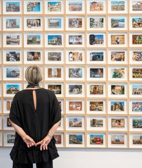 Imagen secundaria 2 - Arriba, Calvo revisa uno de los muebles instalados en el IVAM. Sobre estas líneas, detalle de sus libros intervenidos y su colección de postales