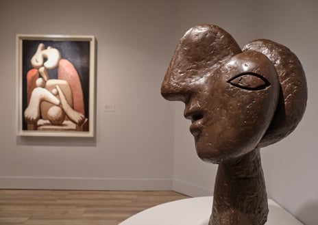 Imagen secundaria 1 - Arriba, una joven admira las dos obras que Picasso hizo en homenaje a Julio González, apenas una semana después de su muerte, en 1942. Ambas tienen el mismo título: 'Cabeza de toro'. Abajo, de izquierda a derecha, 'Mujer con sillón rojo' frente a 'Cabeza de mujer (ambas realizadas en Boisgeloup) y 'El hombre del cordero'