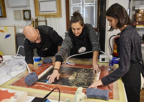 Imagen secundaria 1 - Arriba, Carlota Santabárbara en el transcurso de una de sus conferencias sobre restauración. Arriba, el equipo de Julia Betancor interviene una pieza. A la derecha, una obra compuesta de plásticos espera su turno