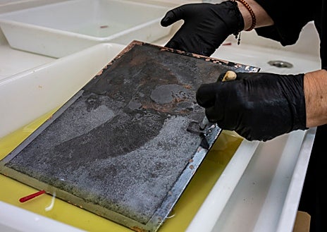 Imagen secundaria 1 - Arriba, la conservadora y restauradora de la Academia de Bellas Artes Silvia Viana, retirando el acerado de una plancha de Goya. Sobre estas líneas, de izquierda a derecha, Viana trabajando con el número 5 de los 'Disparates' ('Disparate volante'), y algunas de las matrices del artista en el taller de estampación de Calcografía Nacional, dispuestas para ser estudiadas y restauradas 