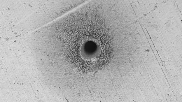 El orificio  mide sólo 120 micrómetros de diámetro y tiene forma cónica. Los daños sólo pueden apreciarse con un microscopio electrónico
