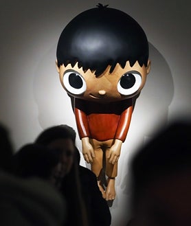 Imagen secundaria 2 - Sobre estas líneas, algunas de las colaboraciones y 'toys' del artista. A la derecha, su 'pequeño Maurizio'. Arriba, un fotógrafo se afana con una escultura monumental del gato Gunter