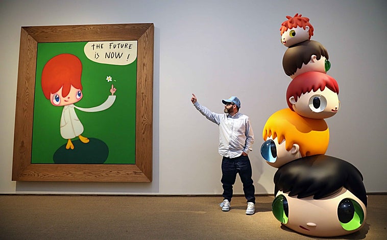 Imagen principal - Sobre estas líneas, una joven contempla la versión de Calleja de Mickey Mouse. A la derecha, el artista traslada uno de sus cuadros. Arriba, Calleja entre dos de sus obras, una pintura y una escultura, en el Centro Cultural Fundación Unicaja