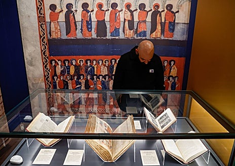 Imagen secundaria 1 - Arriba, la directora de la BNE, Ana Santos, junto al vicepresidente de Cantabria, Pablo Zuloaga. En la exposición hay 25 piezas, entre ellas una edición facsímil del Beato, como se muestra en la última fotografía