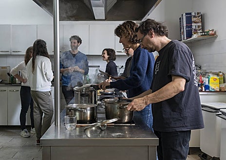 Imagen secundaria 1 - Arriba, el compositor Hugo Gómez-Chao en su estudio. Sobre estas líneas, algunos de los becarios preparan la comida en la cocina comunitaria. A la derecha, vistas de Roma desde la terraza de la Academia