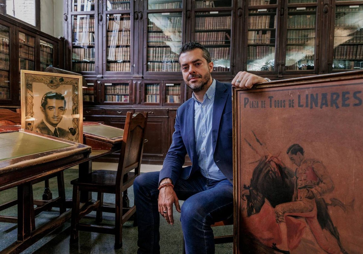 El entrevistado posa en el Ateneo con retratos del mito muerto en Linares