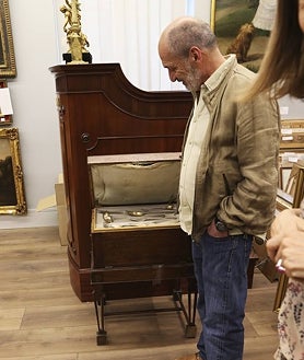 Imagen secundaria 2 - Arriba, Consuelo Durán junto a parte de la vajilla de la boda de Jaime de Armiñán y Elena Santonja (lleva sus iniciales). Sobre estas líneas, a la izquierda, dibujo de Elena en la cocina y, a la derecha, Eduardo de Armiñán, junto a un mueble con piezas de cubertería que pertenece a la familia  