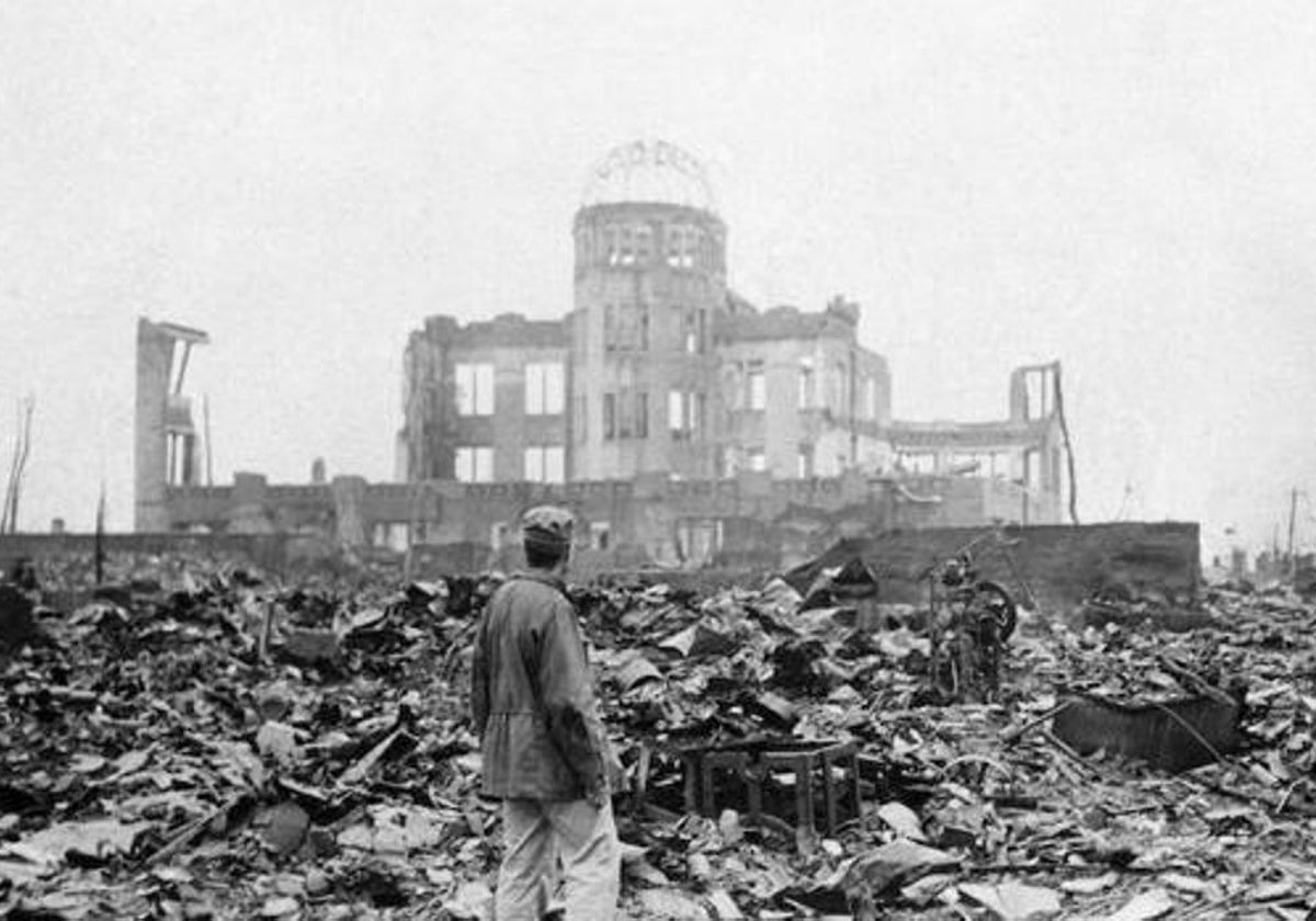 Un hombre mira los restos de un edificio tras la caída de la bomba de Hiroshima