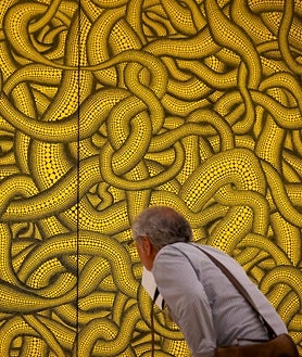 Imagen secundaria 2 - Sobre estas líneas, 'Sala de espejos del infinito'. A la derecha, un hombre observa una de las obras colgadas en el Guggenheim. Arriba, detalle del montaje de la sección 'La fuerza de la vida'