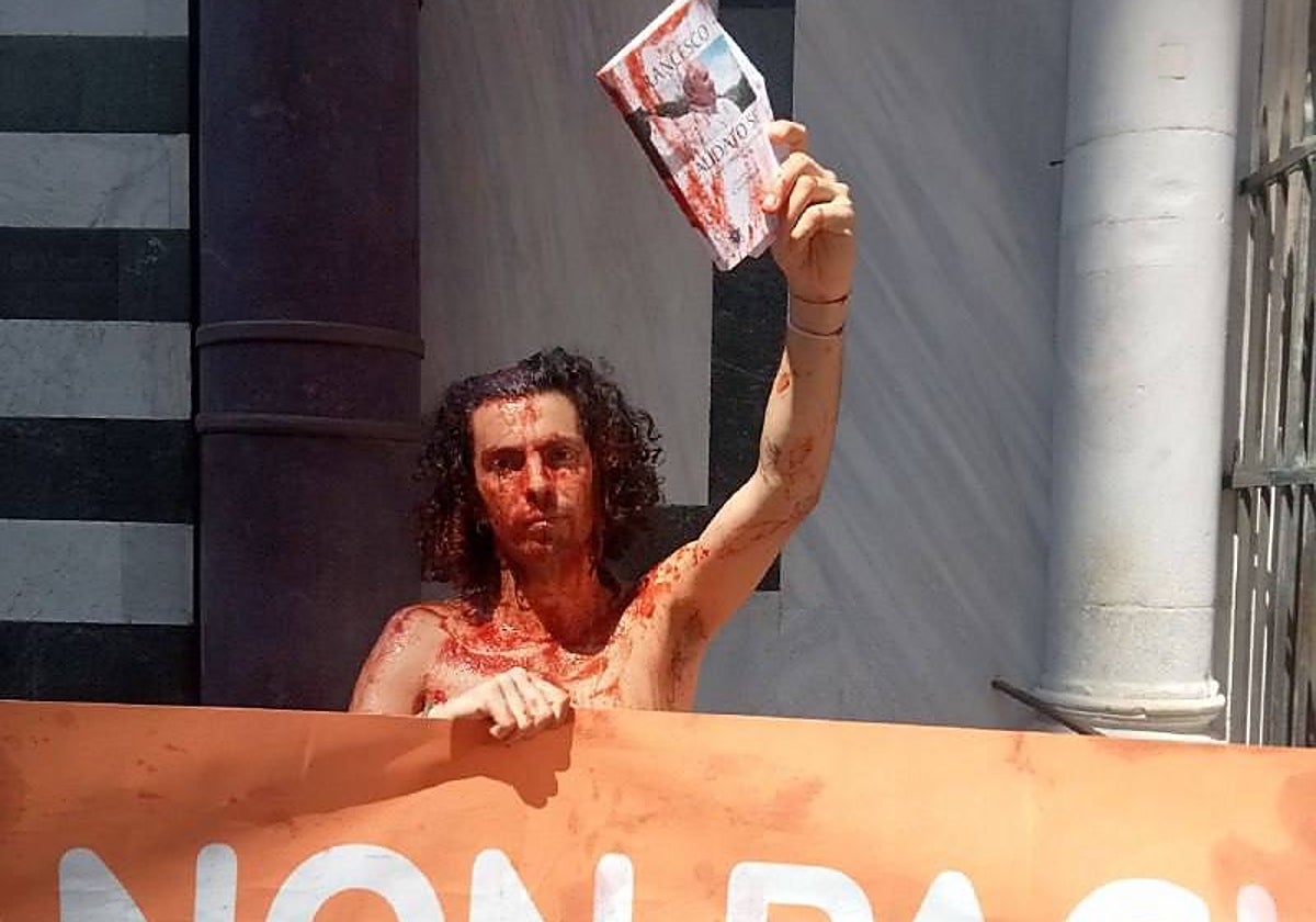 Uno de los cinco activistas sostiene un libro del Papa Francisco durante la protesta