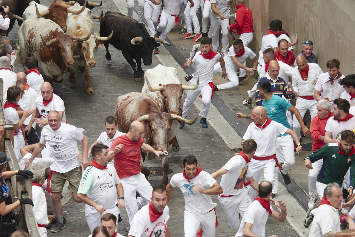 Los participantes corren delante de los toros durante el primer «encierro» de las fiestas de San Fermín en Pamplona