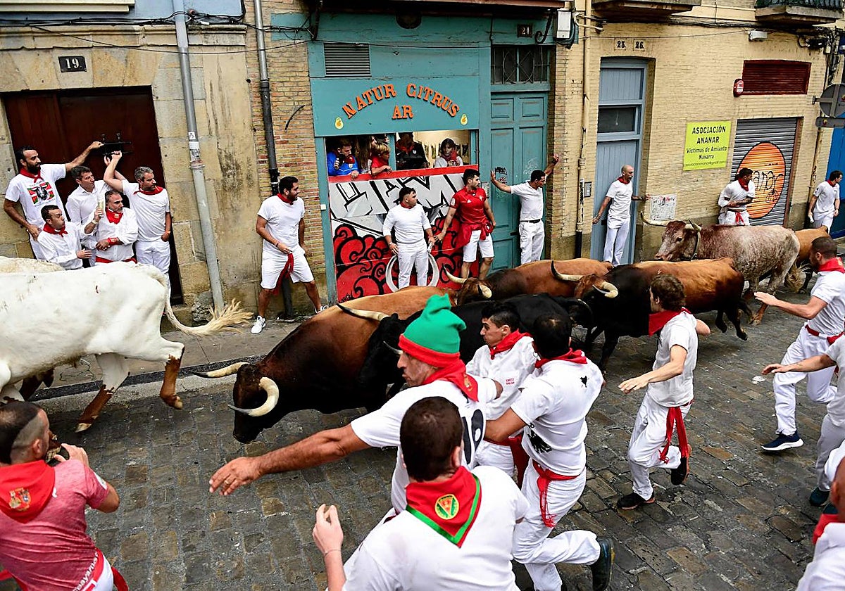 Los participantes corren delante de los toros durante el primer «encierro» de las fiestas de San Fermín en Pamplona