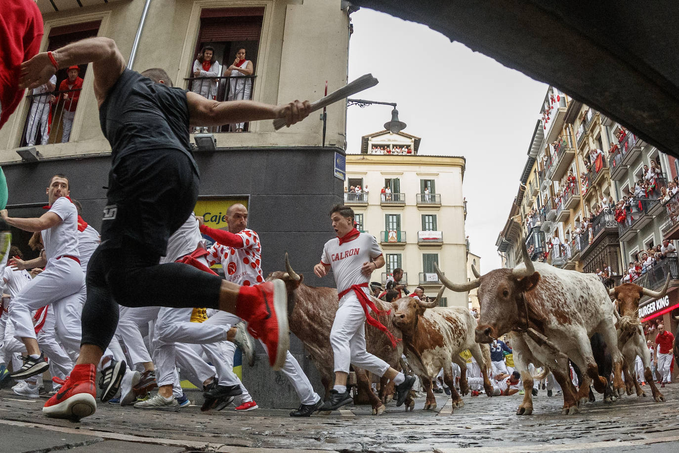 Los toros de la ganadería La Palmosilla a su llegada a la curva de Mercaderes con Estafeta en el primer encierro de los sanfermines 2023