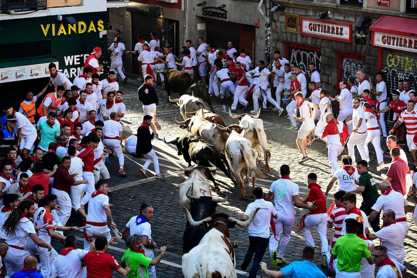 Los participantes corren delante de los toros en el cuarto encierro de los Sanfermínes 2023
