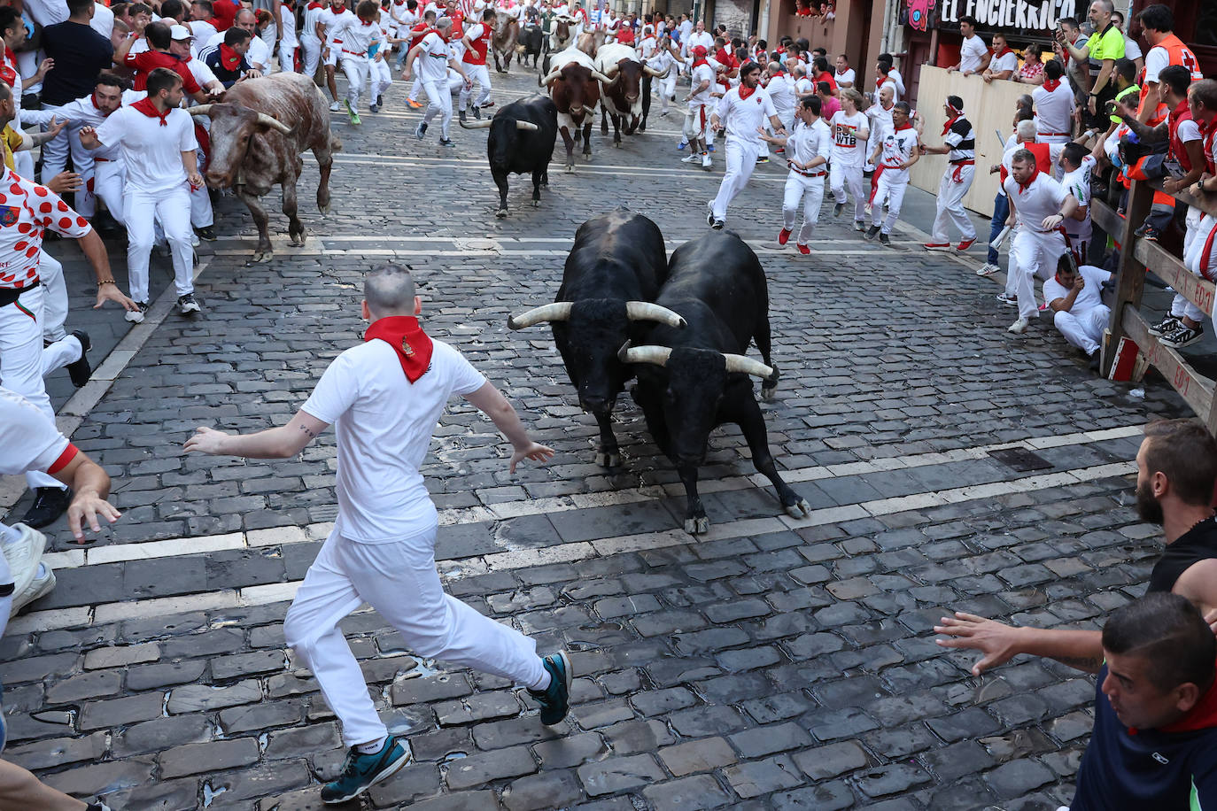 Un mozo cara a cara con toros de la ganadería de Victoriano del Río, este jueves en Pamplona