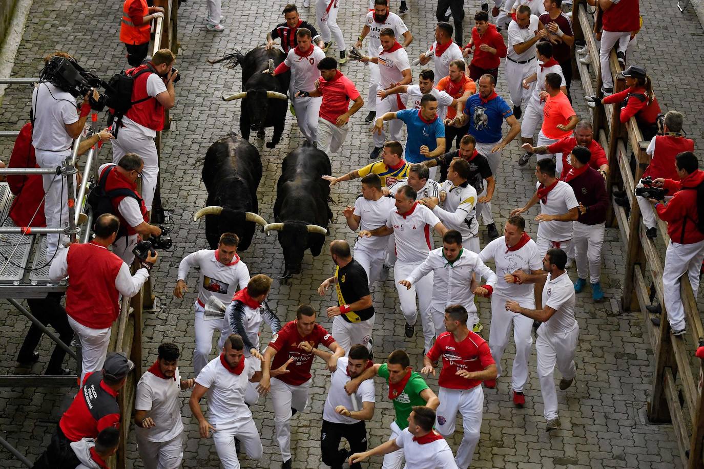 Los mozos perseguidos por los toros de la ganadería de Victoriano del Río en el séptimo encierro de los Sanfermínes