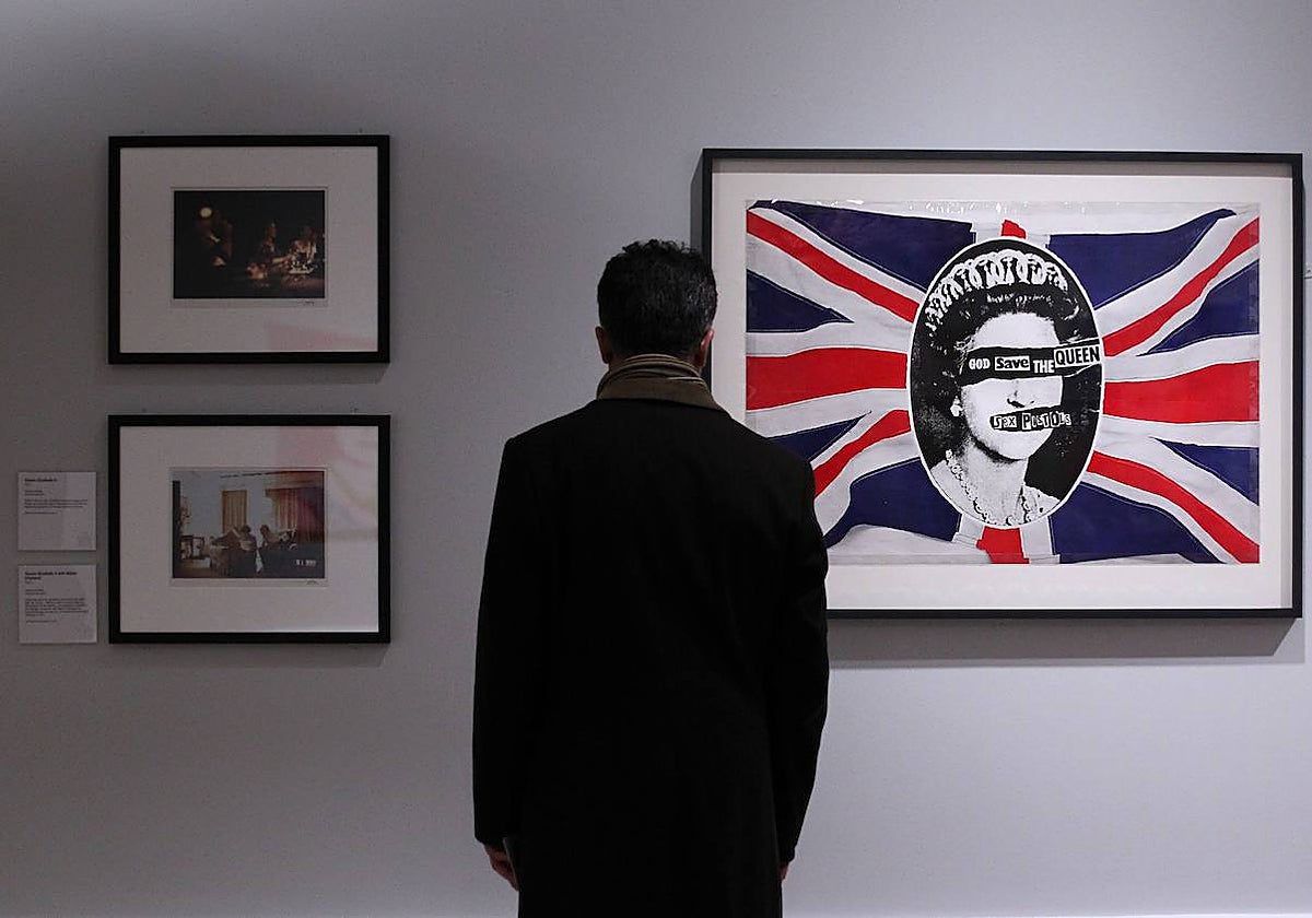 Un hombre observa el diseño de Jamie Reid para 'God Save The Queen' en una exposición