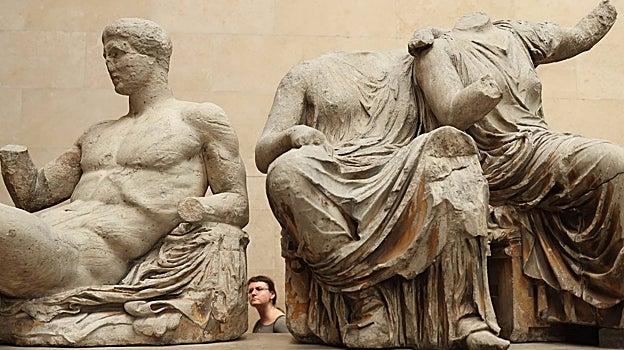 Una mujer observa esculturas en mármol que pertenecieron al Partenón