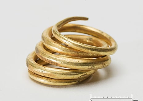 Imagen secundaria 1 - Los medallones y perlas hallados formarían un magnífico collar. Abajo, anillos de oro e imagen de las piezas tras ser desenterradas