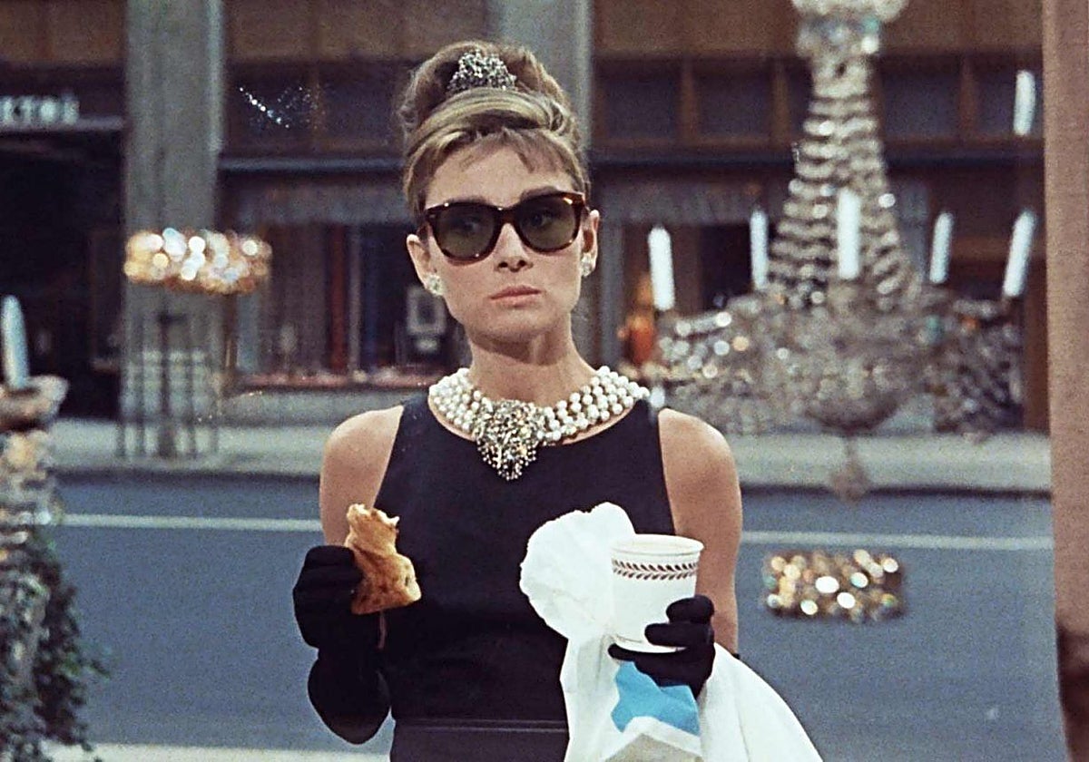 Imposible concebir el filme sin la magia de una Audrey Hepburn vestida en su traje de Givenchy con un bollo en la mano frente a Tiffany's