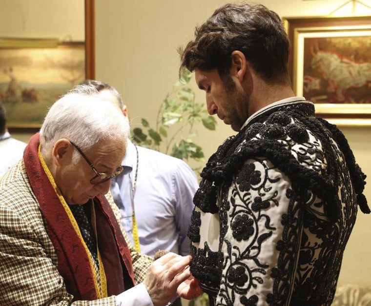 Antonio, de la sastreria, da los últimos retoques a la chaquetilla de un gris perla y negro