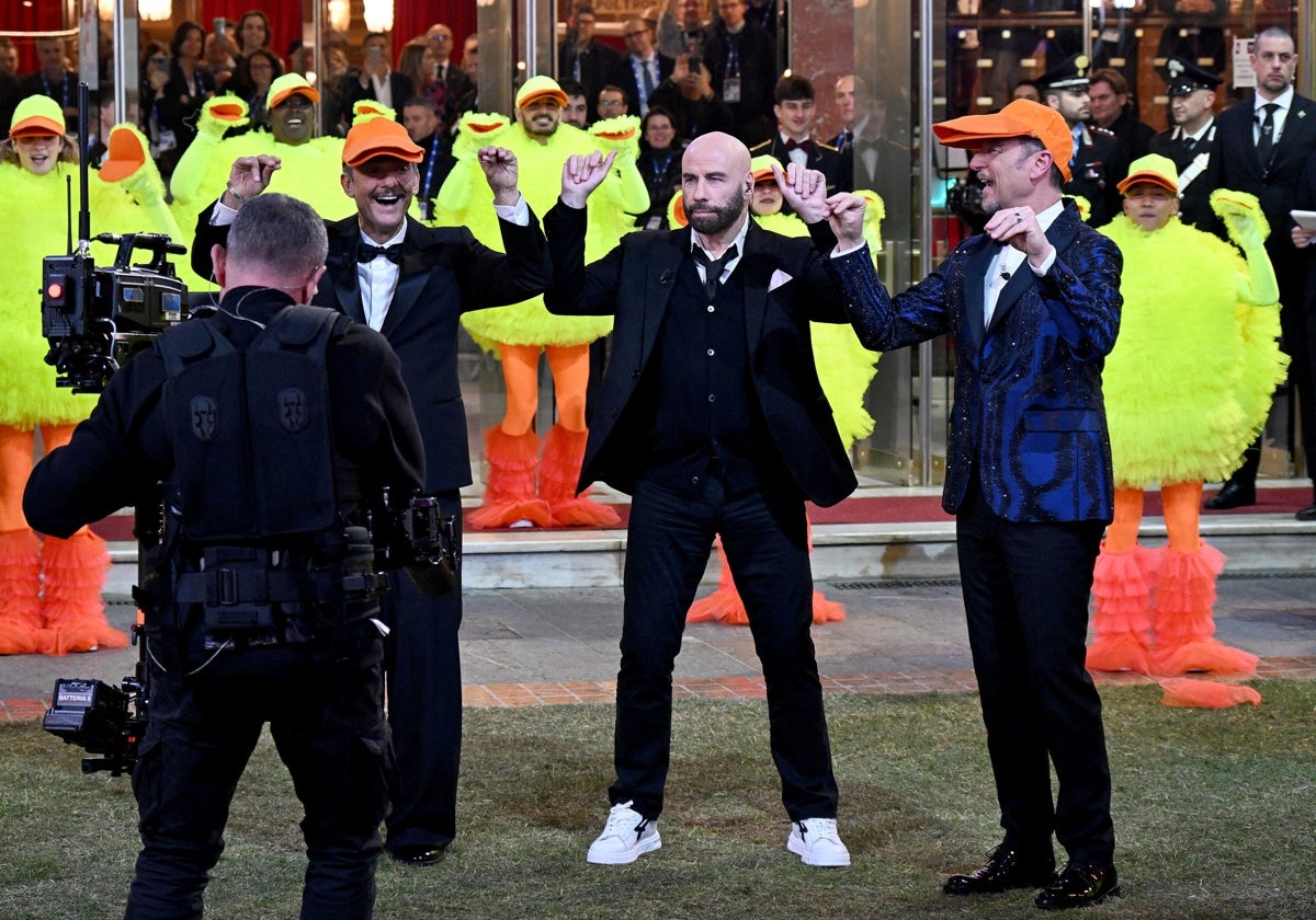 John Travolta al lado de Fiorello (izquierda) y Amadeus (derecha) bailando 'Los Pajaritos'