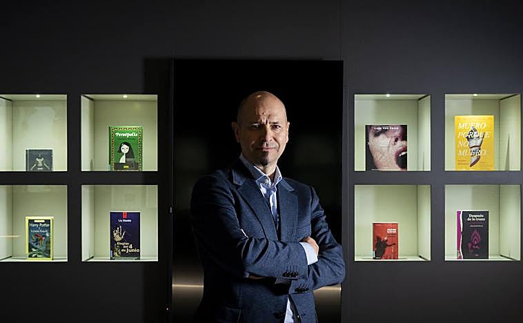 Imagen principal - El nuevo director de la Biblioteca Nacional, Óscar Arroyo, posa con varios libros censurados. Debajo, una edición de 'Fahrenheit 451' intervenido por Joan Fontcuberta. Por último, el sello de la biblioteca de Barcarrota