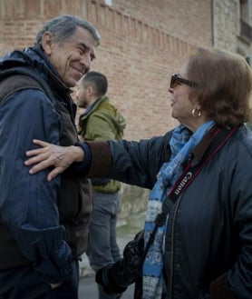 Imagen secundaria 2 - Arriba, García Rodero se fotografía con los diablos en un descanso. Sobre estas líneas, a la izquierda, la fotógrafa con su cámara en la plaza del pueblo; a la derecha, saludando a un colega, Cristóbal Hara, premio Nacional de Fotografía en 2022 