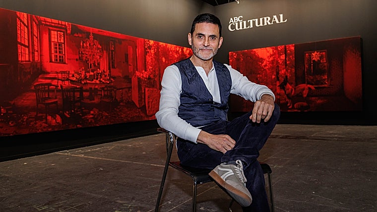 El autor de 'Dejarse quieto flotar' posa para nuestra fotógrafo. De fondo, su obra en temple acrílico sobre seda roja