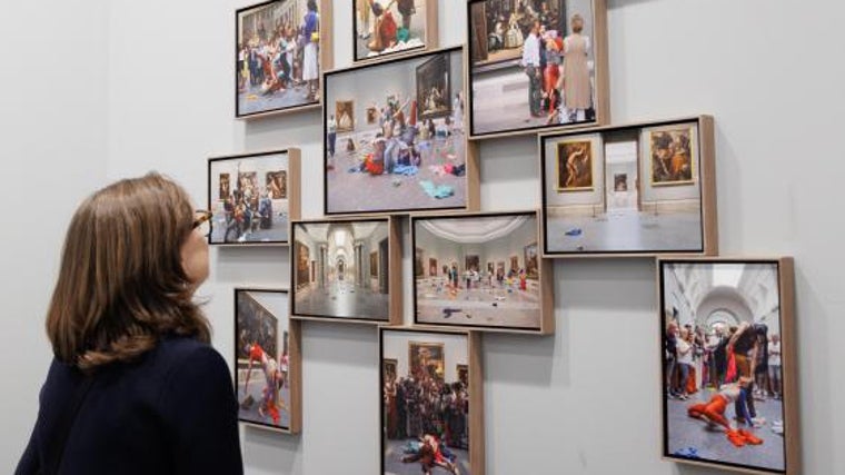 Una mujer admira fotos de una performance de La Ribot en el Prado (estand de Max Estrella)