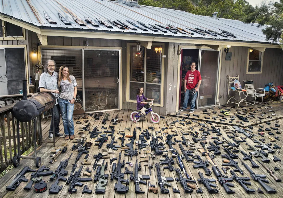 Una familia de Texas posa con su colección de armas en el porche de su casa