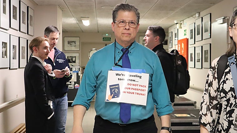 Daryl recuerda a todos los músicos que no deben olvidar su pasaporte dentro de la caja del instrumento, ya que los instrumentos viajan en camiones por tierra, mientras que la orquesta cogerá el avión