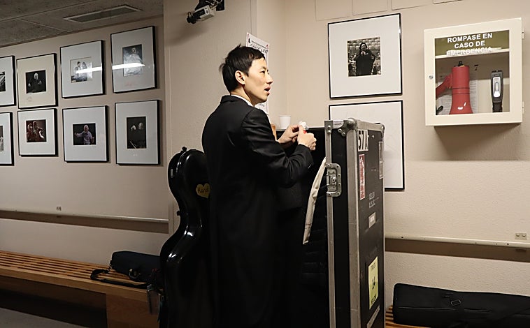 Imagen principal - Loewi Lin se corta las uñas antes del concierto y se toma un café para no perder las fuerzas junto a un compañero mientras otros miembros de la orquesta se van preparando 