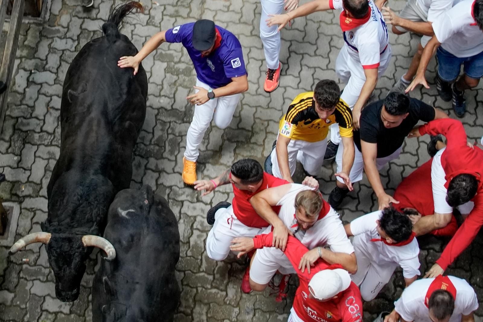 Varios mozos corren junto a dos toros de la ganadería Jandilla