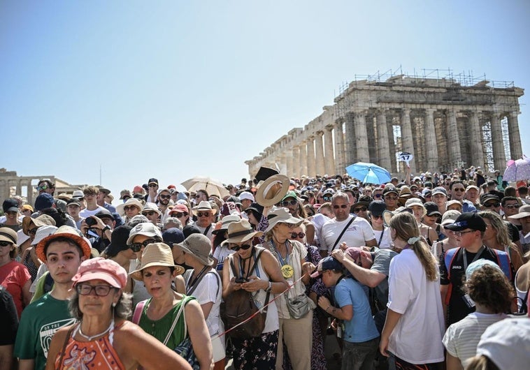 Una gran multitud de turistas visita el templo del Partenón en la colina de la Acrópolis durante una ola de calor