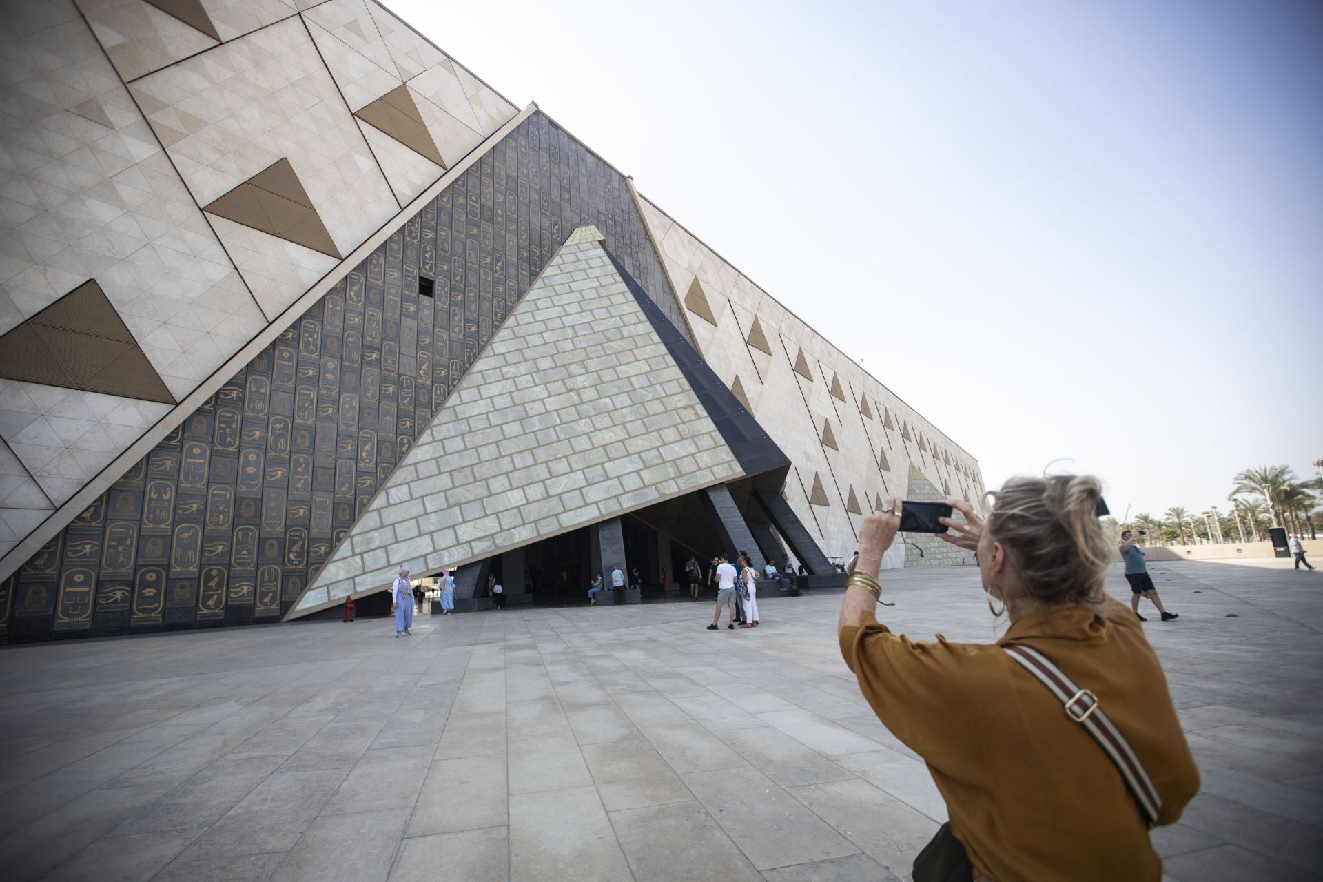 Una mujer fotografía la entrada al Gran Museo Egipcio de Giza