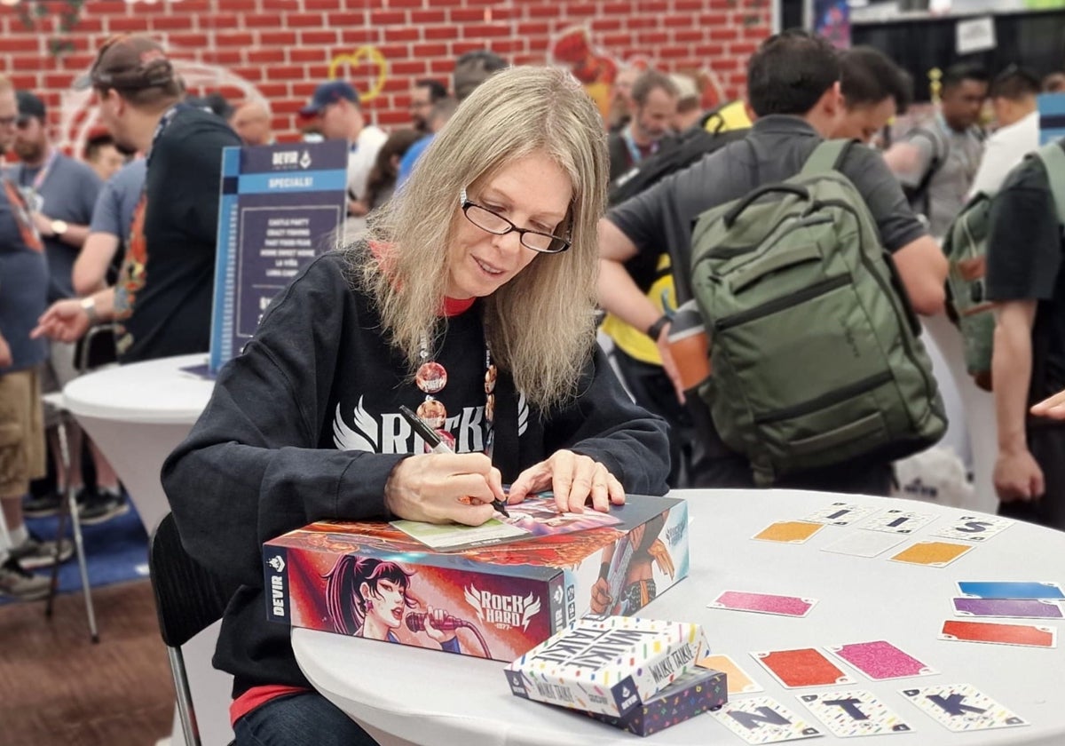 La bajista de The Runaways, Jackie Fox, firmando ejemplares de su juego de mesa 'Rock Hard 1977'